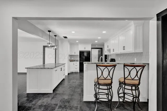 a kitchen with a table chairs refrigerator and microwave