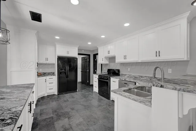 a kitchen that has a refrigerator a sink a stove and cabinets