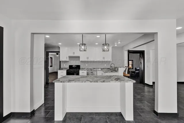 a large white kitchen with a large window