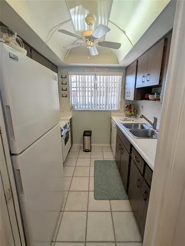 a kitchen with stainless steel appliances granite countertop a sink dishwasher stove and cabinets with wooden floor