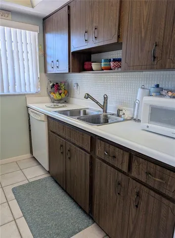 a kitchen with a refrigerator sink and cabinets