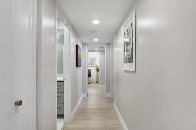 a view of a hallway with wooden floor