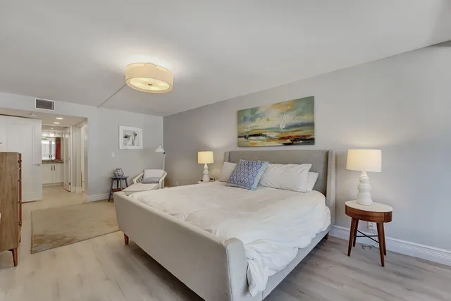 a spacious bedroom with a bed and a lamp