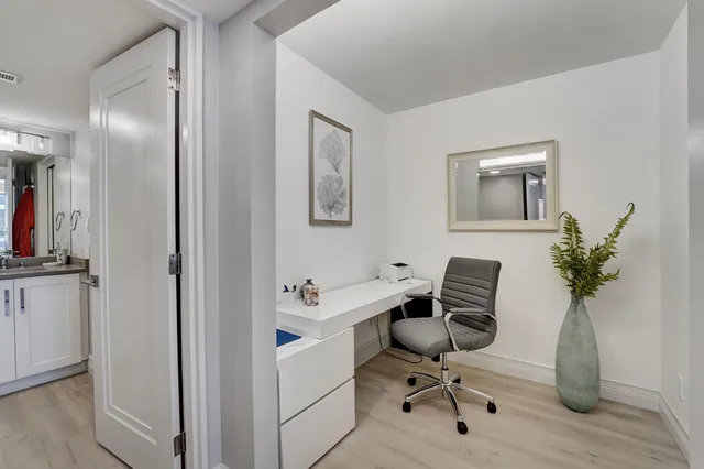 a view of a workspace with furniture and a bathroom