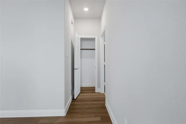 a view of a hallway with wooden floor