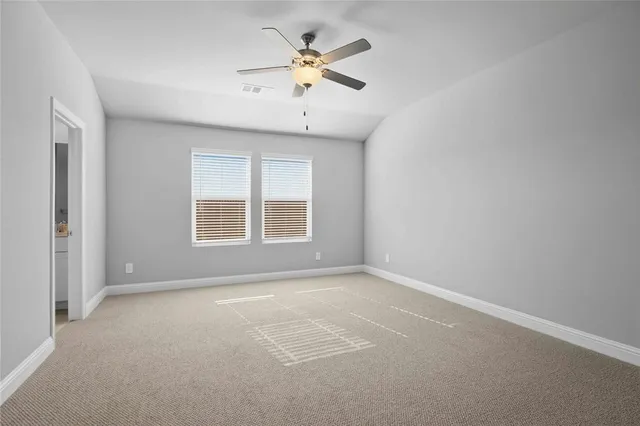 an empty room with a window and a ceiling fan