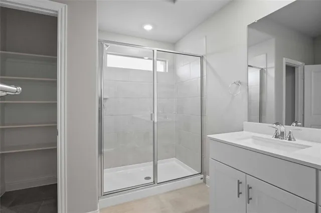 a bathroom with a shower sink and mirror