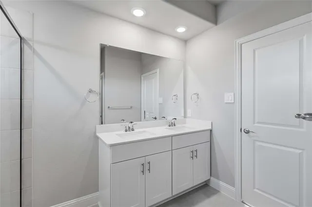 a spacious bathroom with a double vanity sink and mirror
