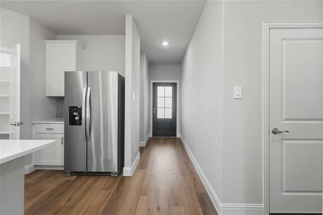 a view of hallway with wooden floor and electronic appliances