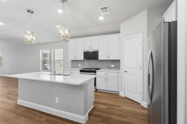 a kitchen with kitchen island a sink stainless steel appliances and cabinets