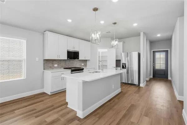 a kitchen with stainless steel appliances refrigerator stove microwave and cabinets