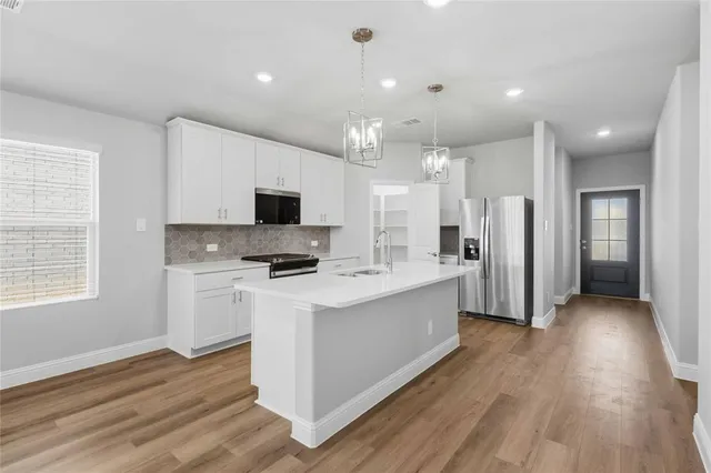 a kitchen with stainless steel appliances refrigerator stove microwave and cabinets