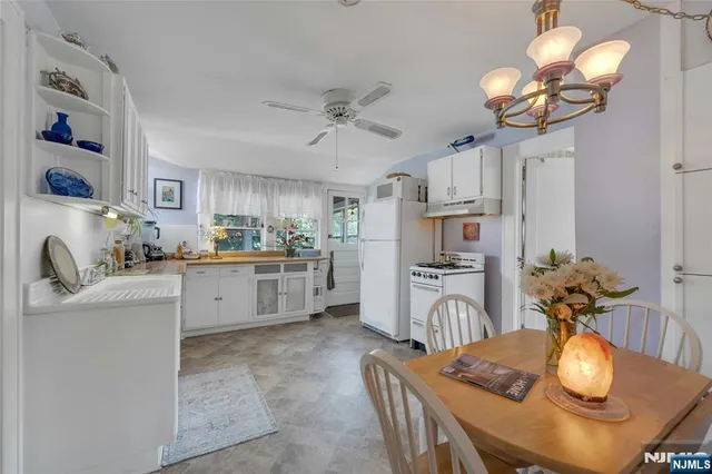 a kitchen with stainless steel appliances granite countertop a sink dishwasher a dining table and chairs with wooden floor