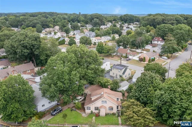 an aerial view of residential houses with outdoor space and trees