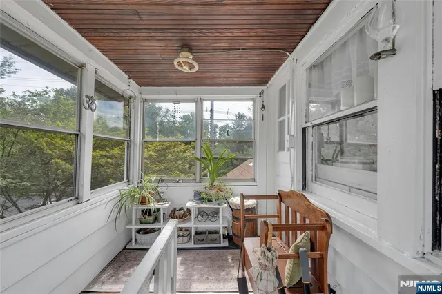a dining room with wooden floor and windows