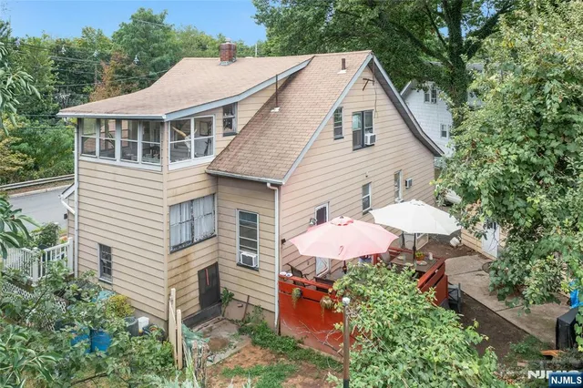 a aerial view of a house with table and chairs under an umbrella