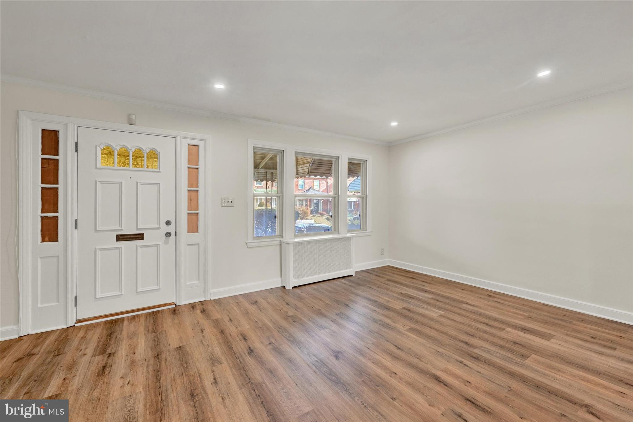 5434 Nelson Avenue Baltimore, MD 21215 - Photo 5 of 17 a view of an empty room with wooden floor and a window