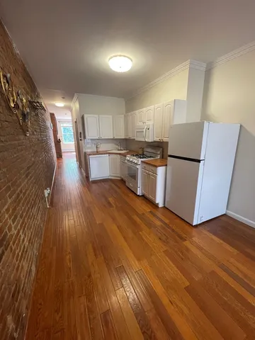 a kitchen with a refrigerator and wooden floor