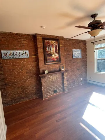 a view of a hardwood floor and brick wall