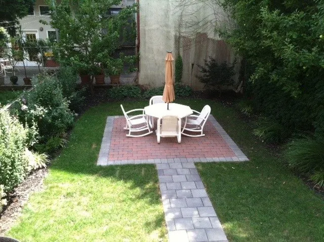 a view of a chair and table in backyard of the house