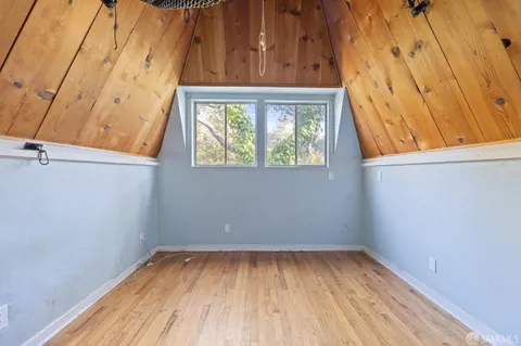 a view of a small space with wooden floor and a window