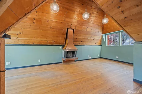 a view of a room with wooden floor and brick walls