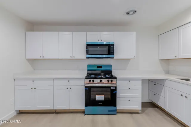 a kitchen with white cabinets and stainless steel appliances