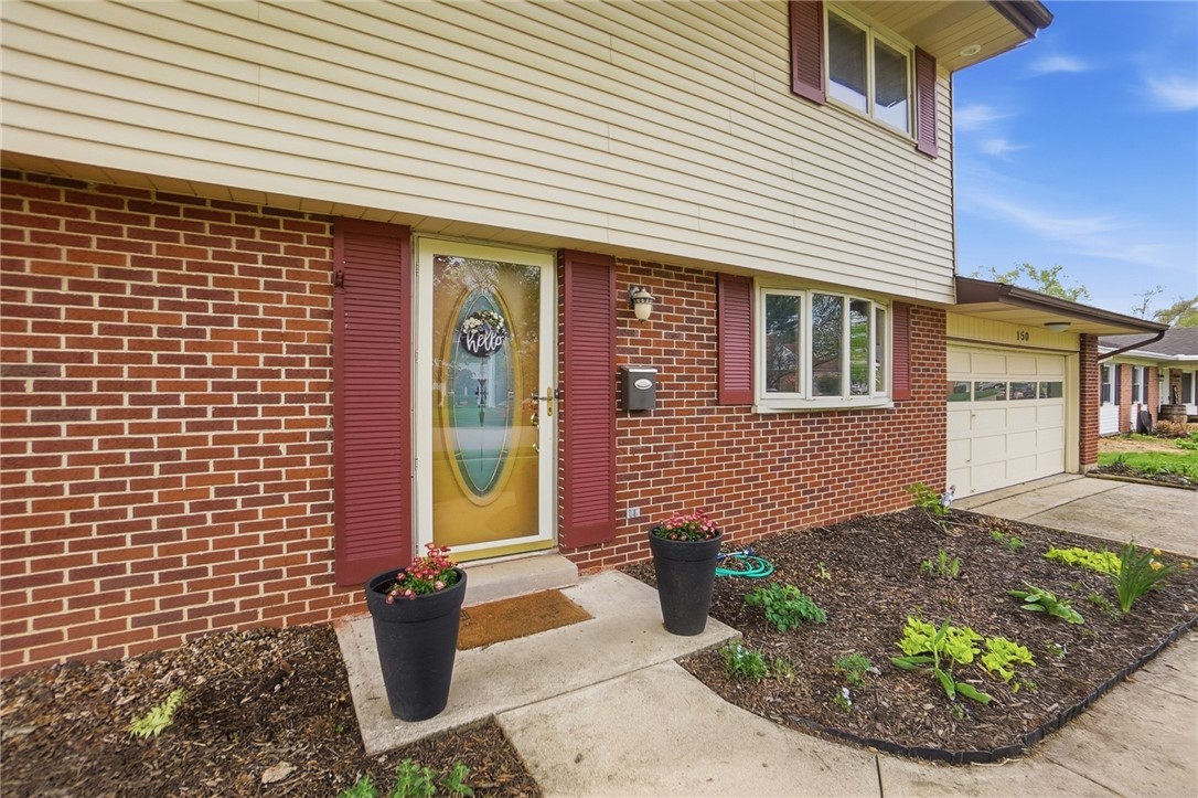 150 Littlejohn Road Troy, OH 45373 - Photo 5 of 40 The home showcases classic brick and siding, complemented by a well-maintained front yard.