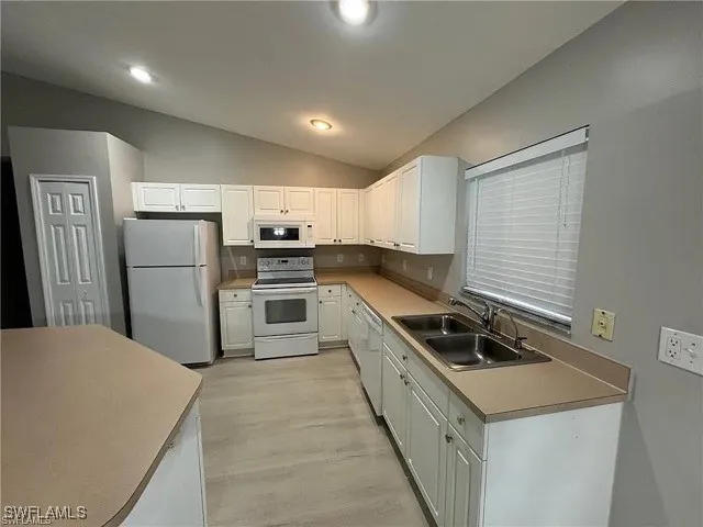 a kitchen with a stove a refrigerator and a sink