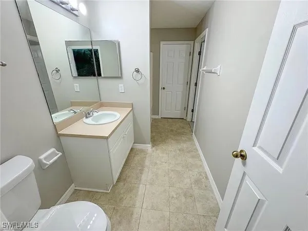 a bathroom with a toilet a sink and a mirror