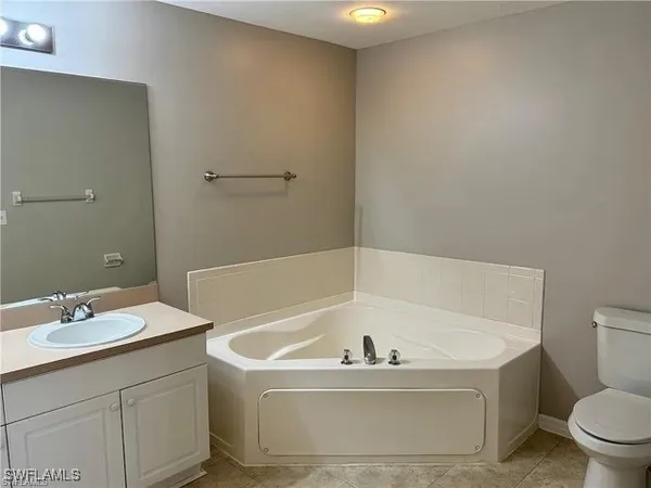 a bathroom with a bathtub sink mirror and toilet