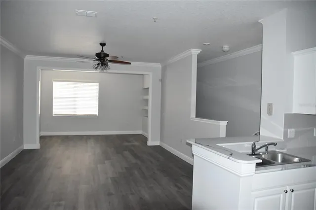 a view of a room with wooden floor and a ceiling fan