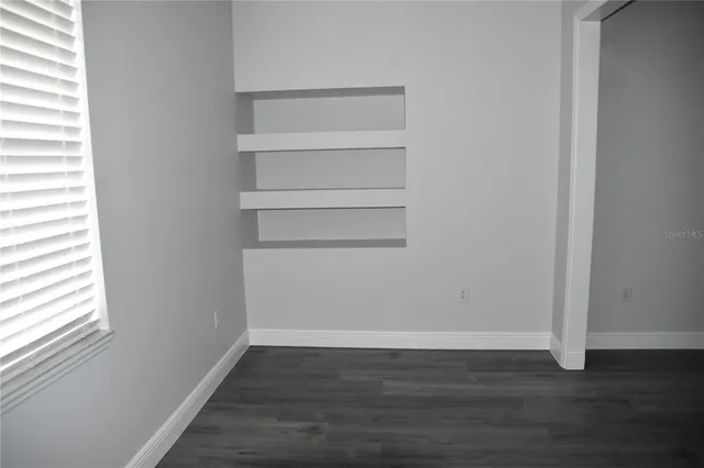 a view of an empty room with wooden floor