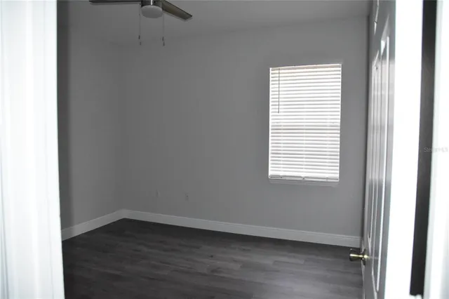 a view of an empty room with wooden floor