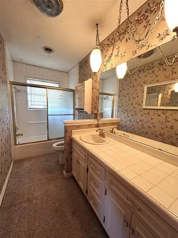 a bathroom with a sink a large mirror and a window