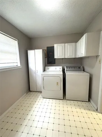 a utility room with cabinets washer and dryer