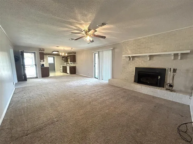 an empty room with windows and fireplace