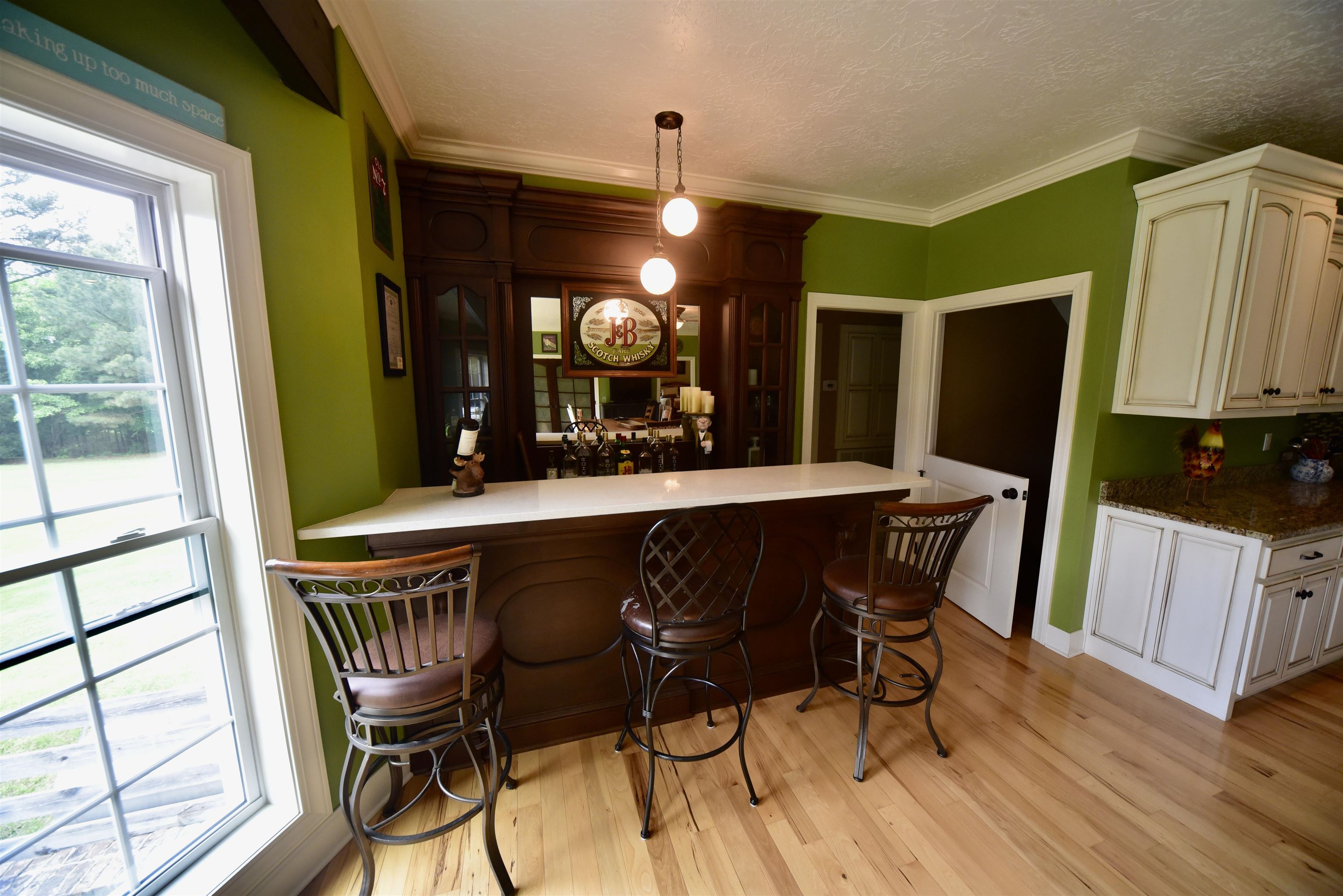 1359 Macks Grove Road Palmersville, TN 38241 - Photo 12 of 40 Indoor dry bar with light wood-type flooring, crown molding, decorative light fixtures, and a textured ceiling