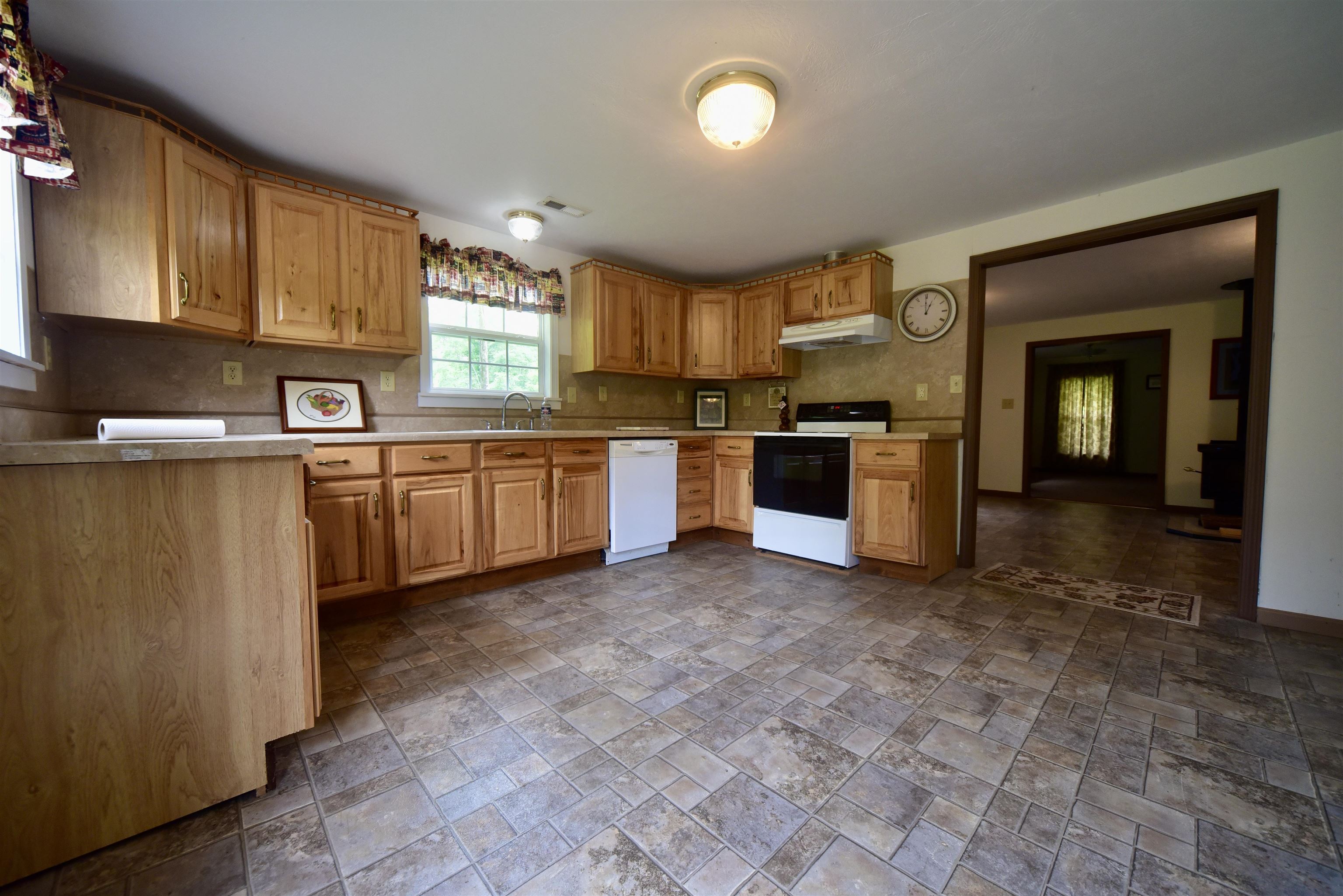 1359 Macks Grove Road Palmersville, TN 38241 - Photo 28 of 40 Kitchen with electric stove, dishwasher, a sink, stone tile flooring, and under cabinet range hood