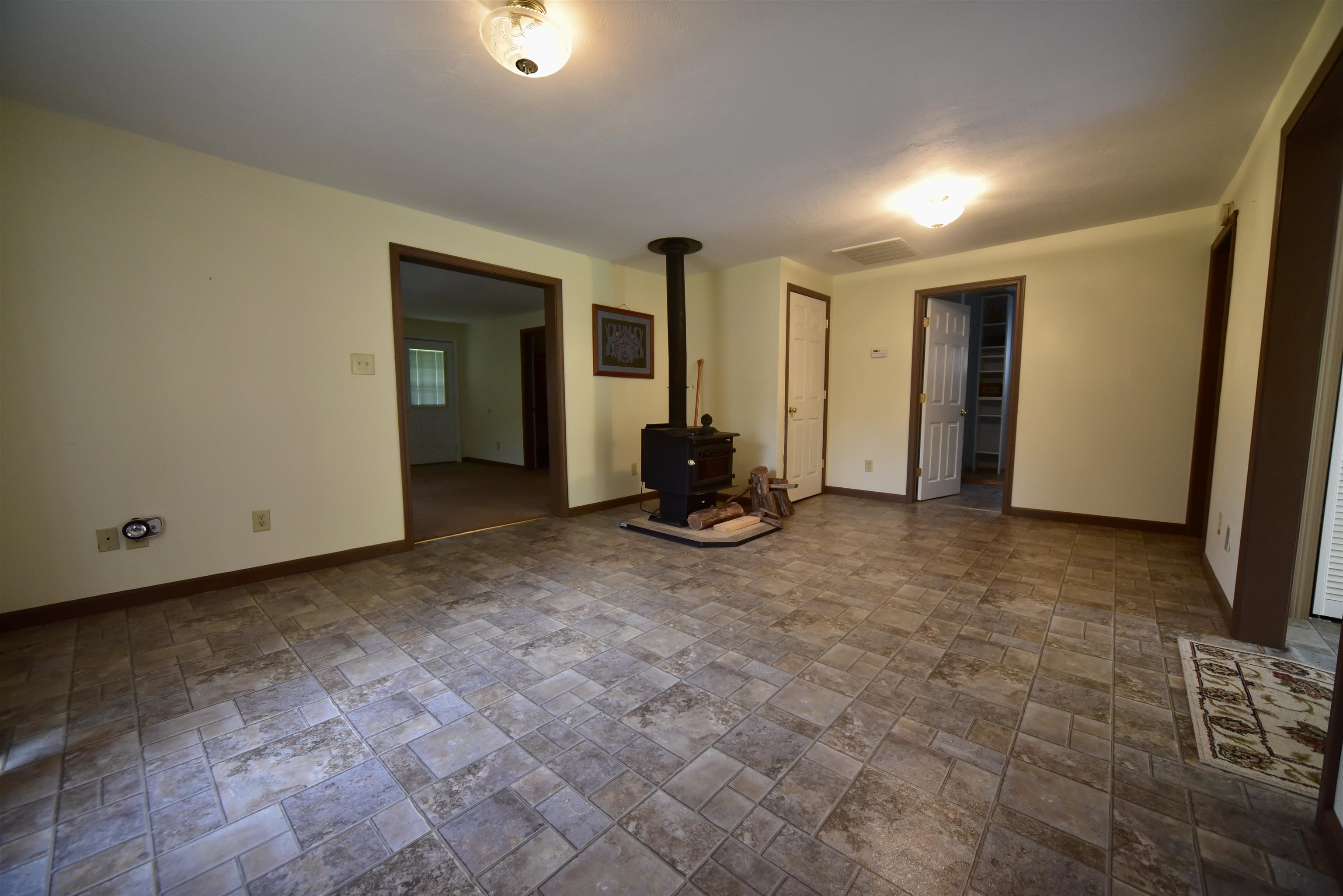 1359 Macks Grove Road Palmersville, TN 38241 - Photo 29 of 40 Spare room with a wood stove, stone tile flooring, and baseboards