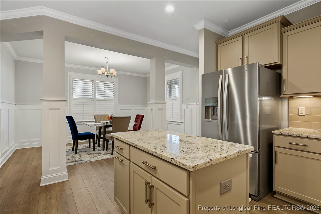 88 Spruce Hollow Circle Spring Lake, NC 28390 - Photo 17 of 48 a kitchen with a kitchen island a table and chairs in it