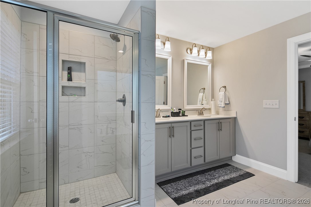 88 Spruce Hollow Circle Spring Lake, NC 28390 - Photo 31 of 48 a bathroom with a shower sink and mirror