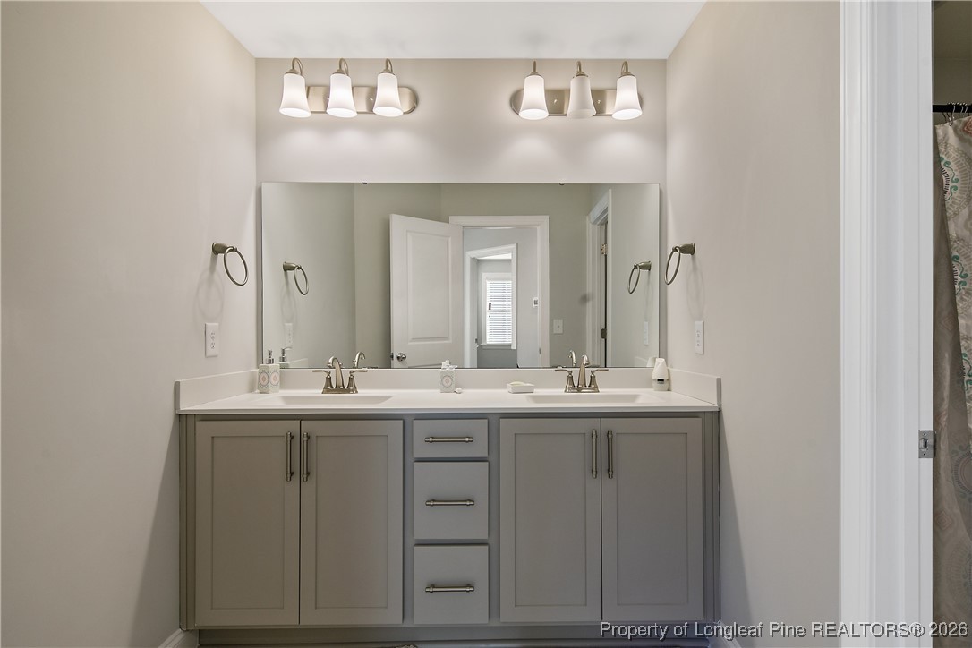 88 Spruce Hollow Circle Spring Lake, NC 28390 - Photo 41 of 48 a bathroom with a double vanity sink and a mirror