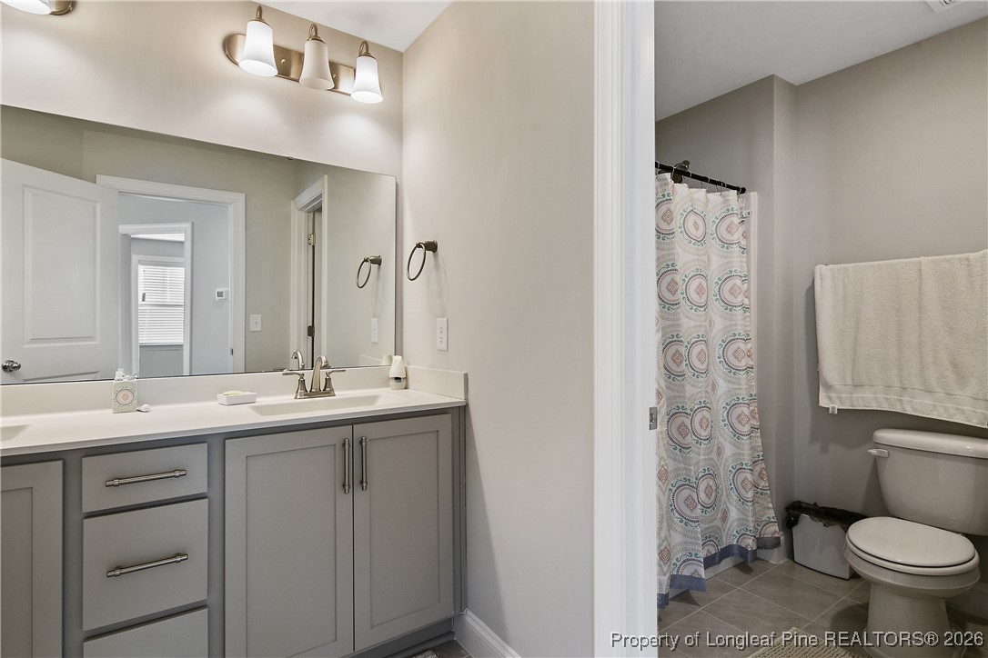 88 Spruce Hollow Circle Spring Lake, NC 28390 - Photo 42 of 48 a bathroom with a granite countertop toilet sink and mirror