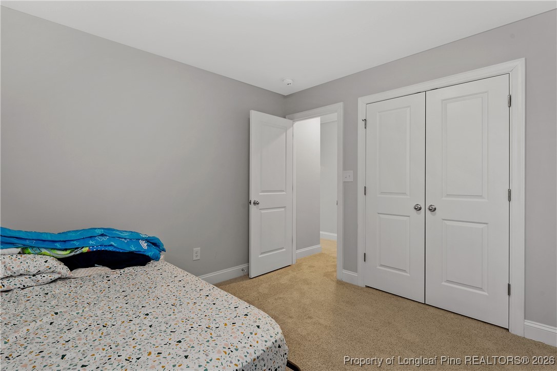 88 Spruce Hollow Circle Spring Lake, NC 28390 - Photo 46 of 48 a bedroom with a bed and hallway