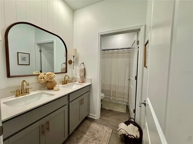 a en suite bathroom with a double vanity sink a mirror and a shower