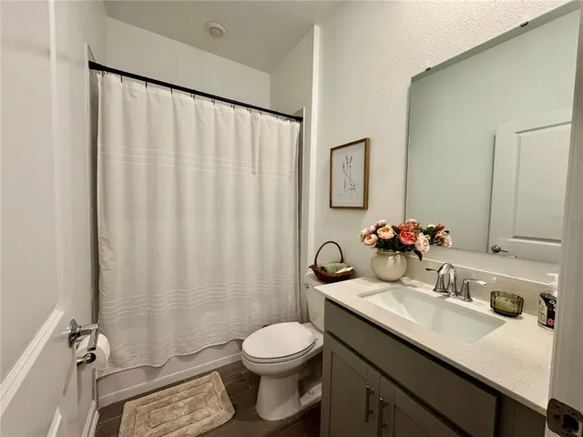 a bathroom with a sink vanity mirror and toilet