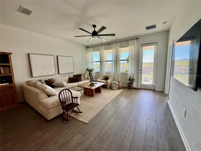 a living room with furniture and a hard wood floor