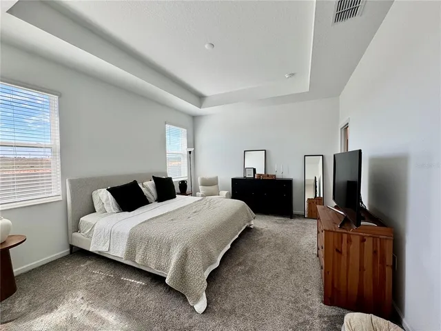 a bedroom with a bed flat screen tv and window