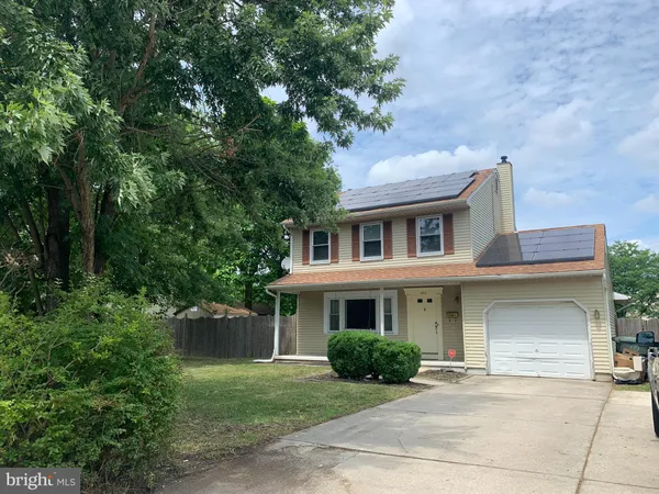 a front view of a house with a garden and plants
